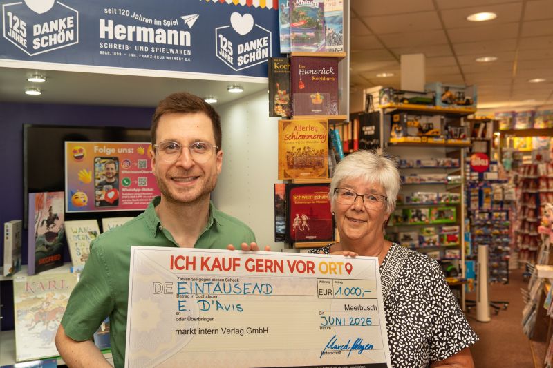 Evi D'Avis (rechts) wäre auch ohne Preisgeld in ihr Lieblingsgeschäft gekommen. Inhaber Franziskus Weinert überreicht den symbolischen Scheck über 1.000 Euro. Foto: Simone Fondel